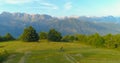 AERIAL: Flying along man riding a bicycle across an empty pasture in mountains. Royalty Free Stock Photo