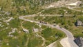 AERIAL: Flying along a steep mountain road in Dolomites and truck climbing it.