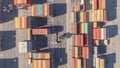 AERIAL: Flying along street running past freight containers in industrial harbor
