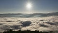 Aerial flying back to reveal silhouette forest foreground with the sea of mist