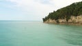 Aerial flying on drone over calm azure sea along coast to horizon