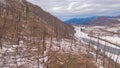 AERIAL Flying over the bleak forest damaged by fire in a snowy valley in Montana Royalty Free Stock Photo