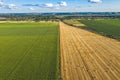 Aerial Flying over fields with straw bales at harvesting time, sunflowers and maize or corn, sunset time, top view. Far village Royalty Free Stock Photo