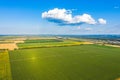 Aerial Flying over fields with straw bales at harvesting time, sunflowers and maize or corn, sunset time, top view. Far village Royalty Free Stock Photo