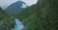 AERIAL: Flying over the stunning turquoise river flowing through the forest. Royalty Free Stock Photo