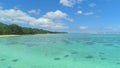 AERIAL: Flying over tranquil waters of the Pacific Ocean near spectacular island