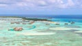 AERIAL: Flying toward an island in the Maldives with abandoned overwater villas.