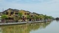 AERIAL: Flying towards an idyllic riverside avenue in a tranquil Vietnamese town