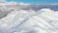 AERIAL: Flying towards the snowy slopes of a ski resort in the spectacular Alps. Royalty Free Stock Photo