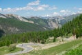 AERIAL: Flying towards a switchback road and tourists cycling in the French Alps Royalty Free Stock Photo