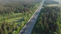 AERIAL: Flying view of a busy highway in picturesque nature during rush hour.