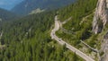 AERIAL: Two sports cars racing on a winding asphalt road in Dolomites Italy. Royalty Free Stock Photo