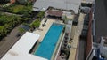 Aerial footage of a man in the pool on the roof of luxury hotel, Kuta, Bali, Indonesia. A drone top down view of a hotel