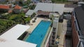Aerial footage of a man in the pool on the roof of luxury hotel, Kuta, Bali, Indonesia. A drone top down view of a hotel