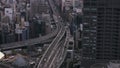 Aerial footage of multilane thoroughfare and road intersection surrounded with town development. Vehicles driving