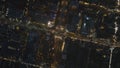 Aerial footage of streets and buildings in urban borough in evening. High angle view of traffic on thoroughfare in night