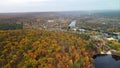 Aerial forward above river with autumn forest