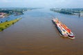 Aerial from a freighter full of containers cruising on the river Merwede near Gorinchem in the Netherlands in a flooded landscape