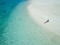 AERIAL: Girl in bikini lying on the sandy beach and suntanning in Cook Islands. Royalty Free Stock Photo