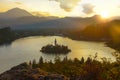 AERIAL: Golden evening sunbeams shine on the picturesque islet in lake Bled. Royalty Free Stock Photo