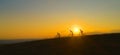 AERIAL: Golden sunbeams shine on friends downhill biking at picturesque sunset.