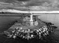 Aerial grayscale view of South Gare Lighthouse under dark cloudy sunset sky in England