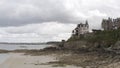 Aerial for the group of people walking on the beach with stony shore with the brick cottages and blue cloudy sky on the Royalty Free Stock Photo