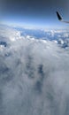 Aerial high in the sky, shot from above the clouds, with the wing of a commercial jet plane Royalty Free Stock Photo