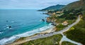 Aerial with Highway One leading to entrance of One Rocky Creek Bridge with ocean coastline view