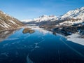 Aerial image of the Chaviolas and Chaste islets on the frozen lake of Silsersee