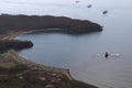 Aerial image of the harbor in calm sea with alone rock in the middle and cargo ships at anchor. Royalty Free Stock Photo