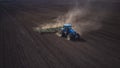 Aerial image of a tractor with seedbed cultivator ploughs field