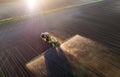 Tractor spraying soil in field