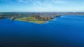 Aerial view 4k wide angle of fields and Rutland water, England, cloudy skies and green patches of forest. Royalty Free Stock Photo