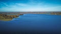 Aerial view 4k wide angle of fields and Rutland water, England, cloudy skies and green patches of forest. Royalty Free Stock Photo