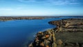 Aerial view 4k wide angle of fields and Rutland water, England, cloudy skies and green patches of forest. Royalty Free Stock Photo