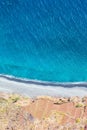 Aerial landscape by the blue Atlantic ocean. Stone beach and adjacent fields on the southern coast of Madeira Island, Portugal. Royalty Free Stock Photo