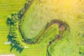 Aerial landscape countryside of winding small river, stream in green field, top view sunset meadow Royalty Free Stock Photo