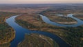 Aerial landscape drone shot with curved river and lakes and forest during sunrise