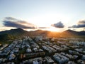 Aerial landscape photo of Recreio dos Bandeirantes beach during sunset, with the sun dipping behind the mountains and