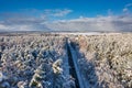 Aerial landscape of the road through snowy forest at winter, Poland Royalty Free Stock Photo