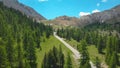 AERIAL: Lone road cyclist rides along the empty asphalt road in the French Alps.