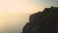 AERIAL: Lonely sailboat sails on the calm sea towards the distant exotic islands