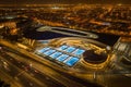 Aerial long-exposure view of vehicles driving by the 360 mall building and courts at night