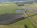 Aerial of meadowland with curving dike cycle lane and water storage on the dutch island of Texel