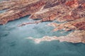Aerial mesmerizing seascape view of turquoise waves hitting red hills and rock formations