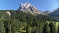 Aerial mountain landscape in the Alps, flying down towards treetops