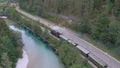 AERIAL: Museum steam locomotive travels along a beautiful river and country road Royalty Free Stock Photo