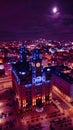 Aerial night view of an illuminated historic building in an urban cityscape with vibrant purple skies in Liverpool, UK Royalty Free Stock Photo