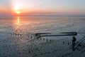 Aerial from an old ship wreck in the Wadden Sea in the Netherlands at sunset with a photographer photographing it Royalty Free Stock Photo